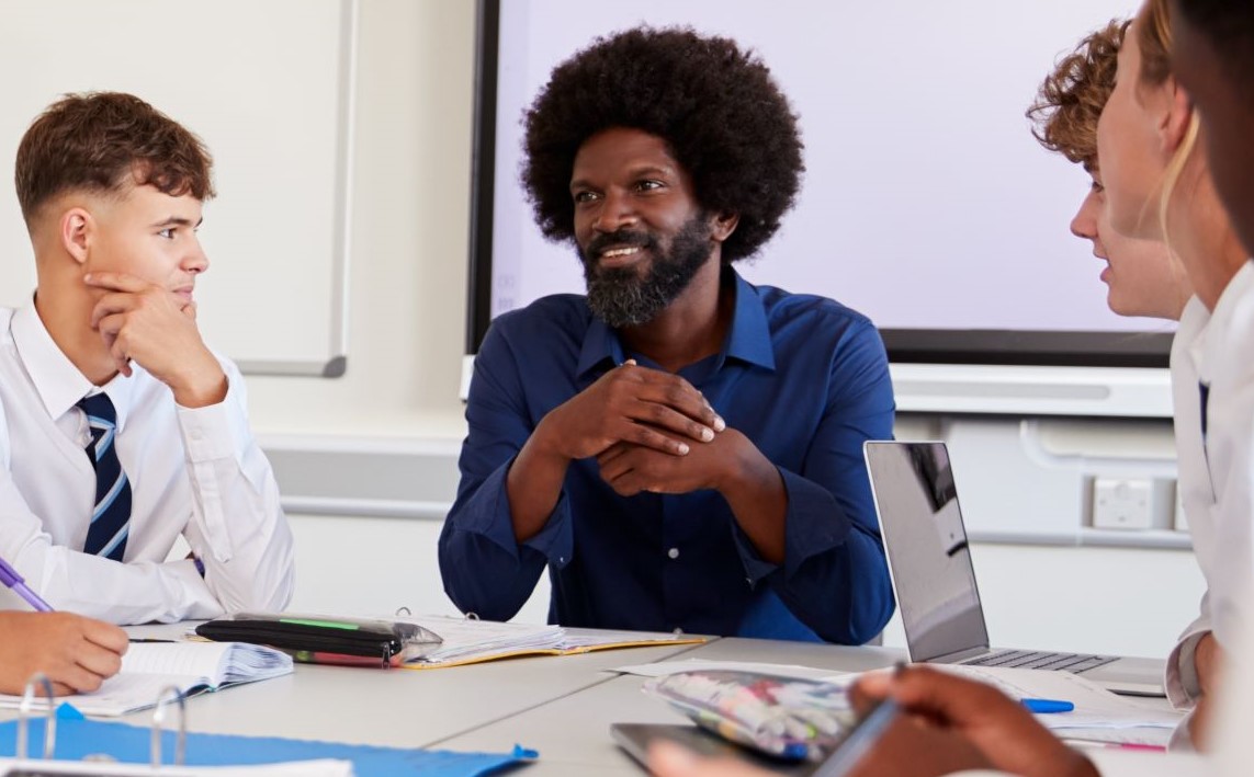 Black male teacher teaching in a classroom with children